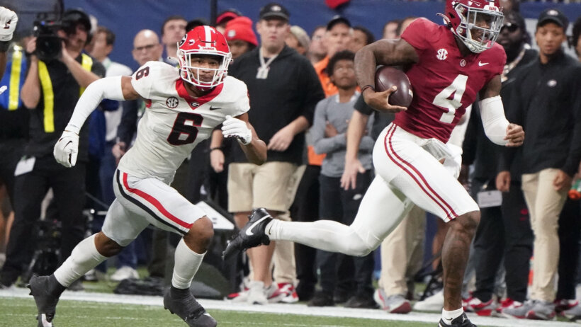 Jalen Milroe runs away from a Georgia defender.