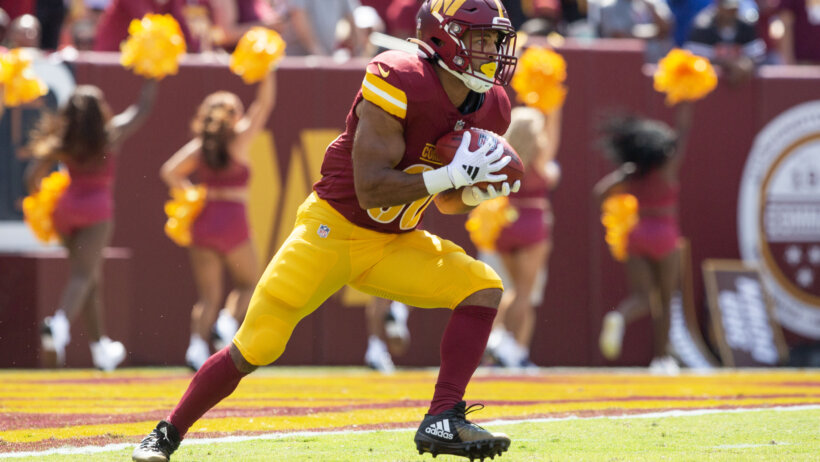 Washington Commanders running back Austin Ekeler fields a kickoff