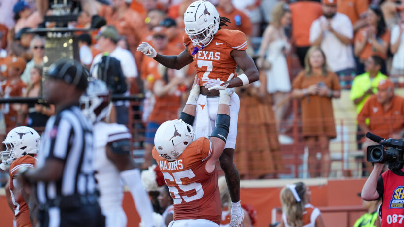Texas Longhorns offensive lineman Jake Majors holds up wide receiver Isaiah Bond