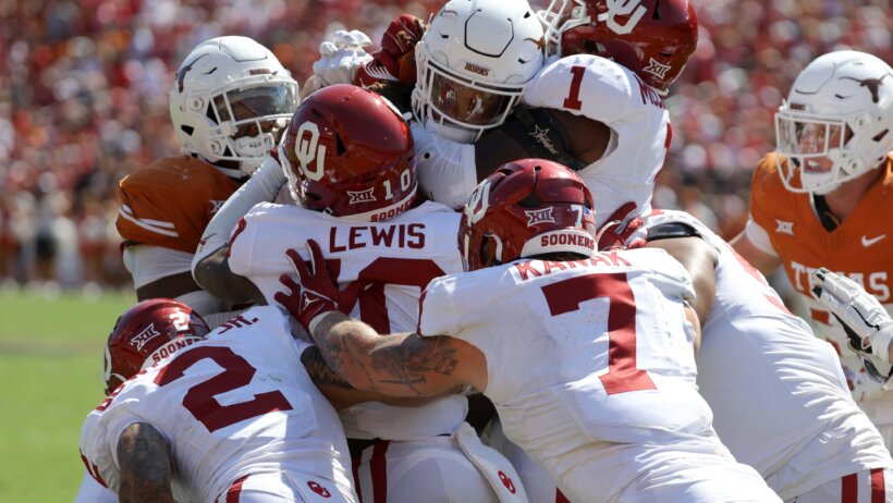 Oklahoma Sooners and Texas Longhorns players in a scrum