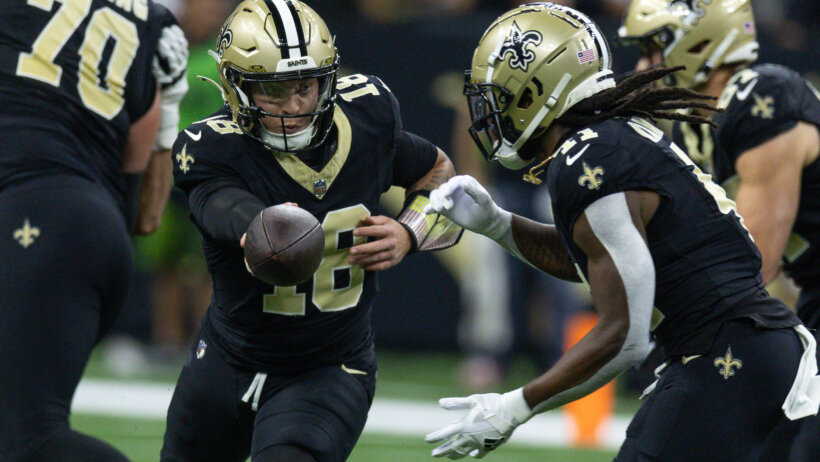 New Orleans Saints quarterback Spencer Rattler hands off to running back Alvin Kamara
