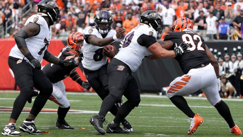 Baltimore Ravens quarterback Lamar Jackson running through Cincinnati Bengals defenders