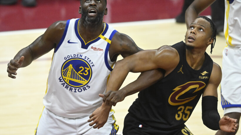 Golden State Warriors forward Draymond Green battles for a rebound with Cleveland Cavaliers forward Isaac Okoro