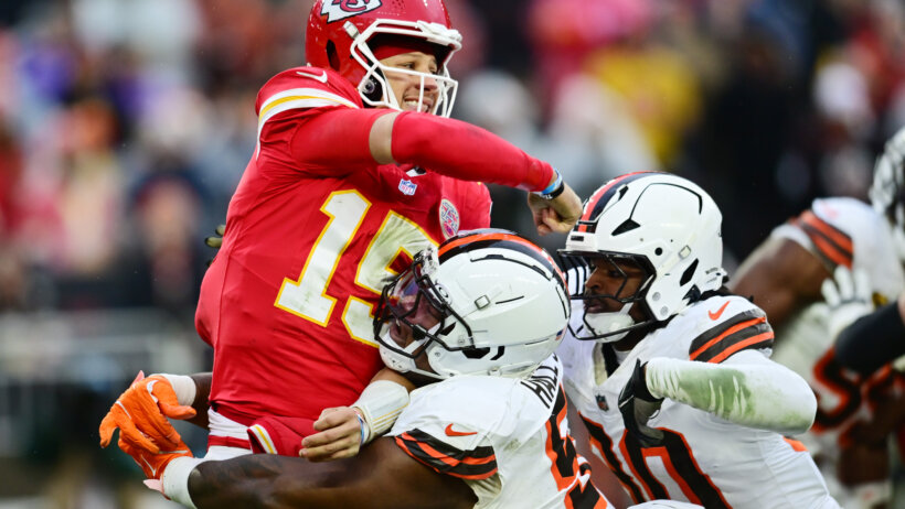 Patrick Mahomes is hit hard by Browns defenders.
