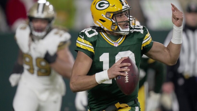 Jordan Love signaling to a receiver downfield