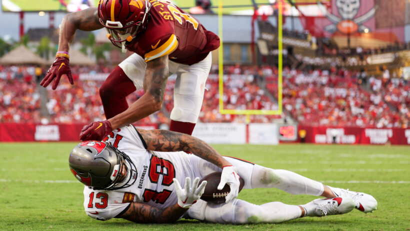 Tampa Bay Buccaneers wide receiver Mike Evans catching a TD pass while Washington Commanders cornerback Benjamin St-Juste defends
