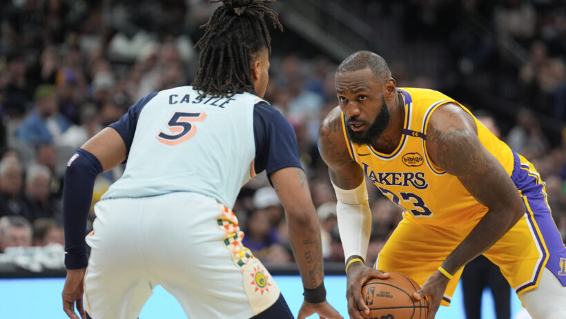 Los Angeles Lakers forward LeBron James holding the ball while San Antonio Spurs guard Stephon Castle defends