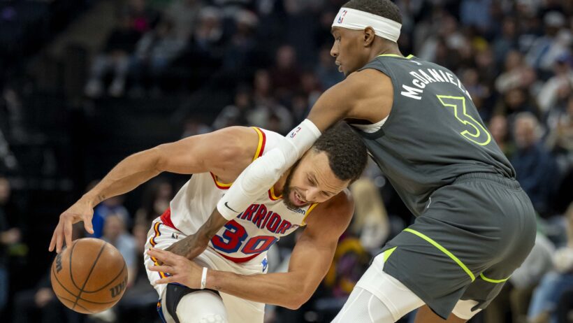Golden State Warriors guard Stephen Curry trying to drive past Minnesota Timberwolves forward Jaden McDaniels