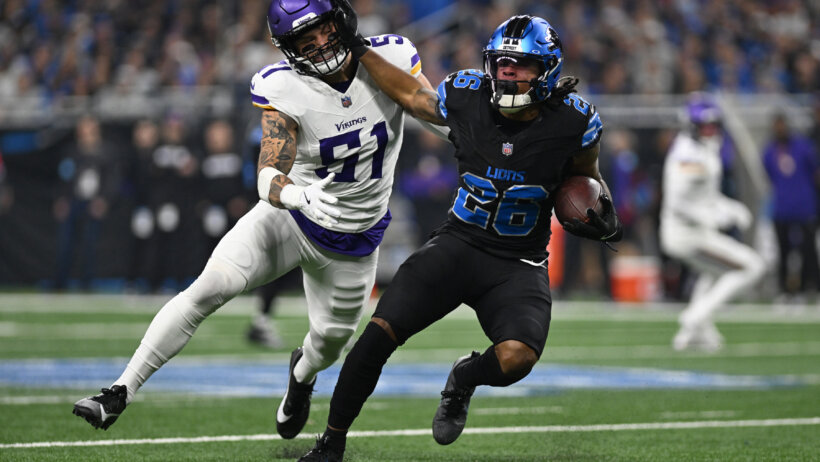 Detroit Lions running back Jahmyr Gibbs stiff arms Minnesota Vikings linebacker Blake Cashman
