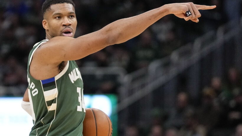 Giannis Antetokounmpo holding ball and pointing
