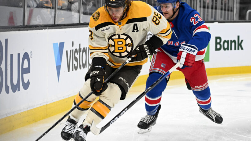 Boston Bruins right wing David Pastrnak controls the puck against New York Rangers defenseman Adam Fox