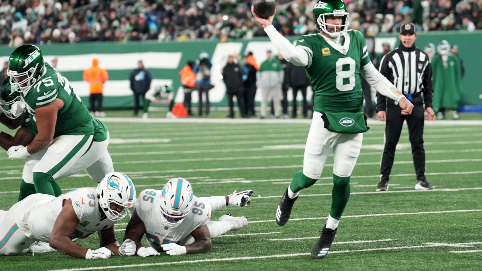 Aaron Rodgers fires a pass versus the Dolphins after eluding the rush.