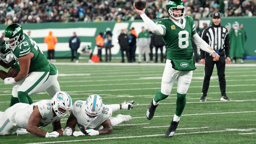 Aaron Rodgers fires a pass versus the Dolphins after eluding the rush.