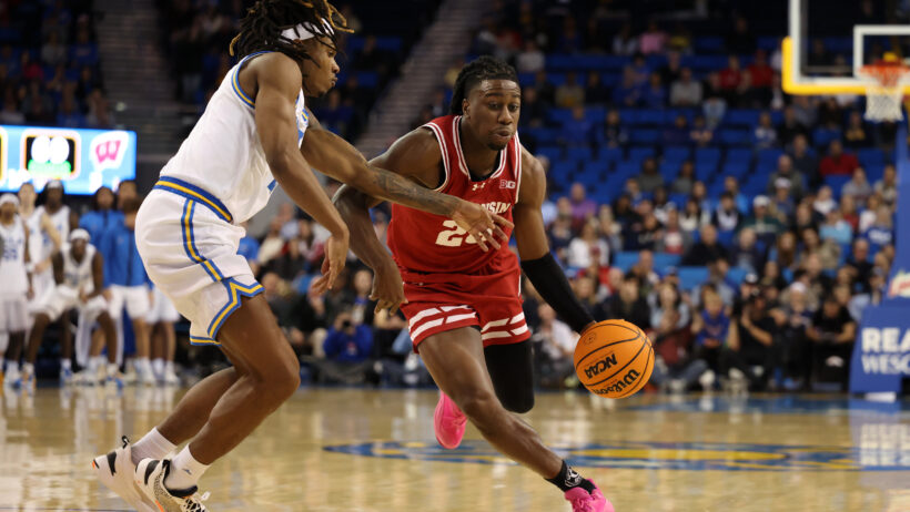 Wisconsin Badgers guard John Blackwell dribbling around UCLA Bruins guard Dylan Andrews