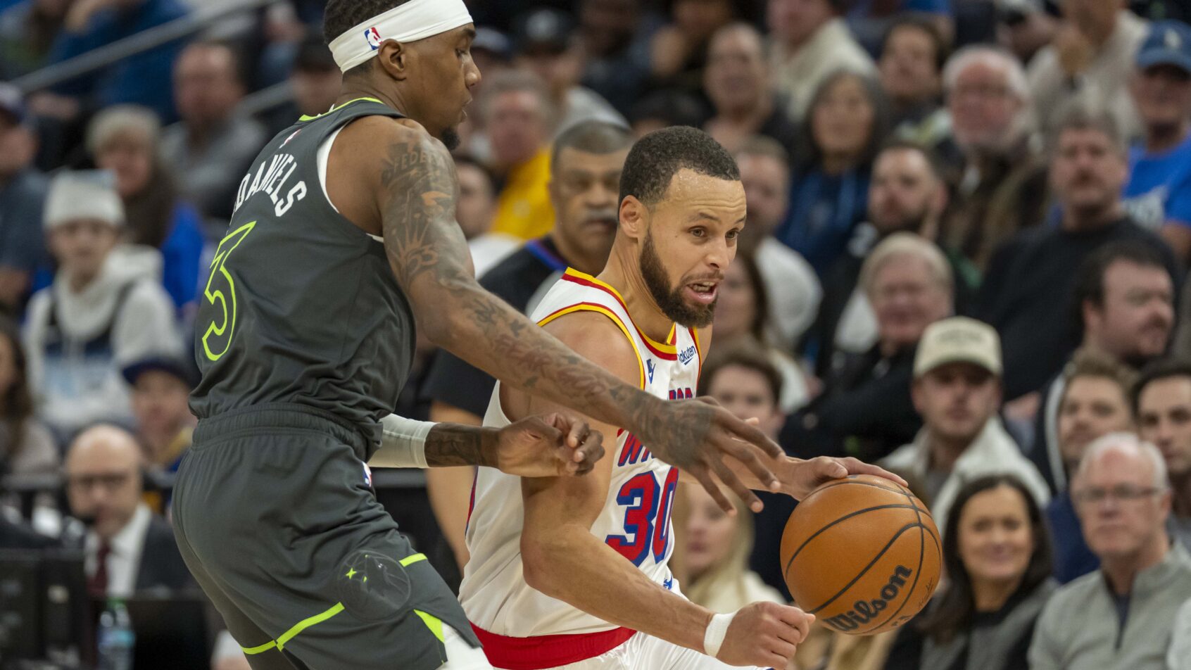 Golden State Warriors guard Stephen Curry drives around Minnesota Timberwolves forward Jaden McDaniels