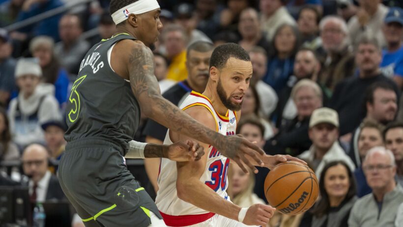 Golden State Warriors guard Stephen Curry drives around Minnesota Timberwolves forward Jaden McDaniels