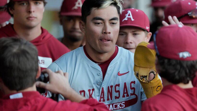 Wehiwa Aloy celebrates in the Arkansas dugout with his teammates.