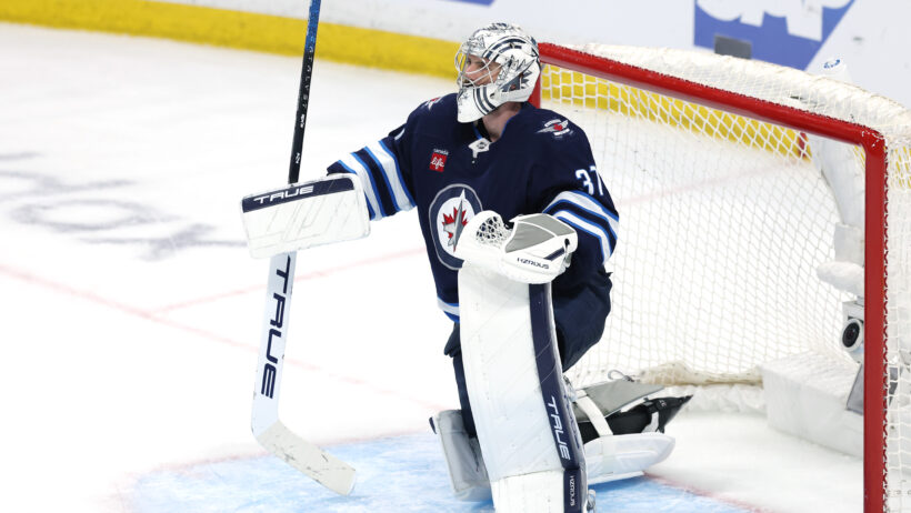 Connor Hellebuyck on one knee
