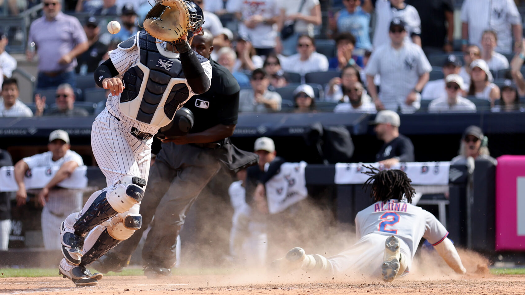 New York Mets pinch runner Luisangel Acuna slides into home plate against the New York Yankees