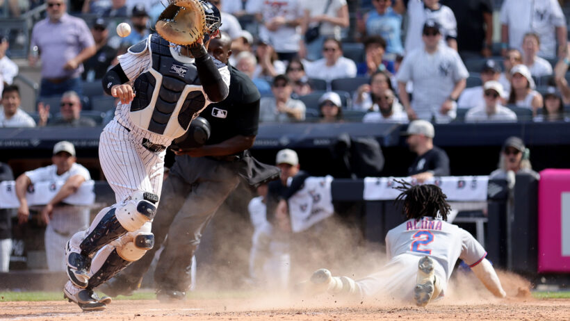 New York Mets pinch runner Luisangel Acuna slides into home plate against the New York Yankees