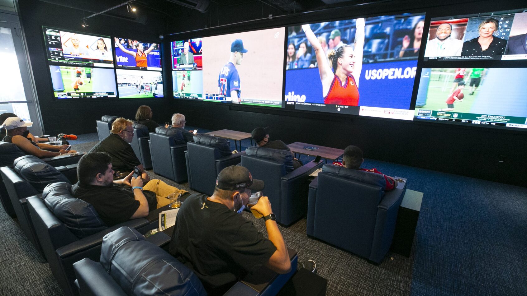 People watch jumbo screens of sports at the FanDuel Sportsbook at the Footprint Center in Phoenix on opening day on Sept. 8, 2021.