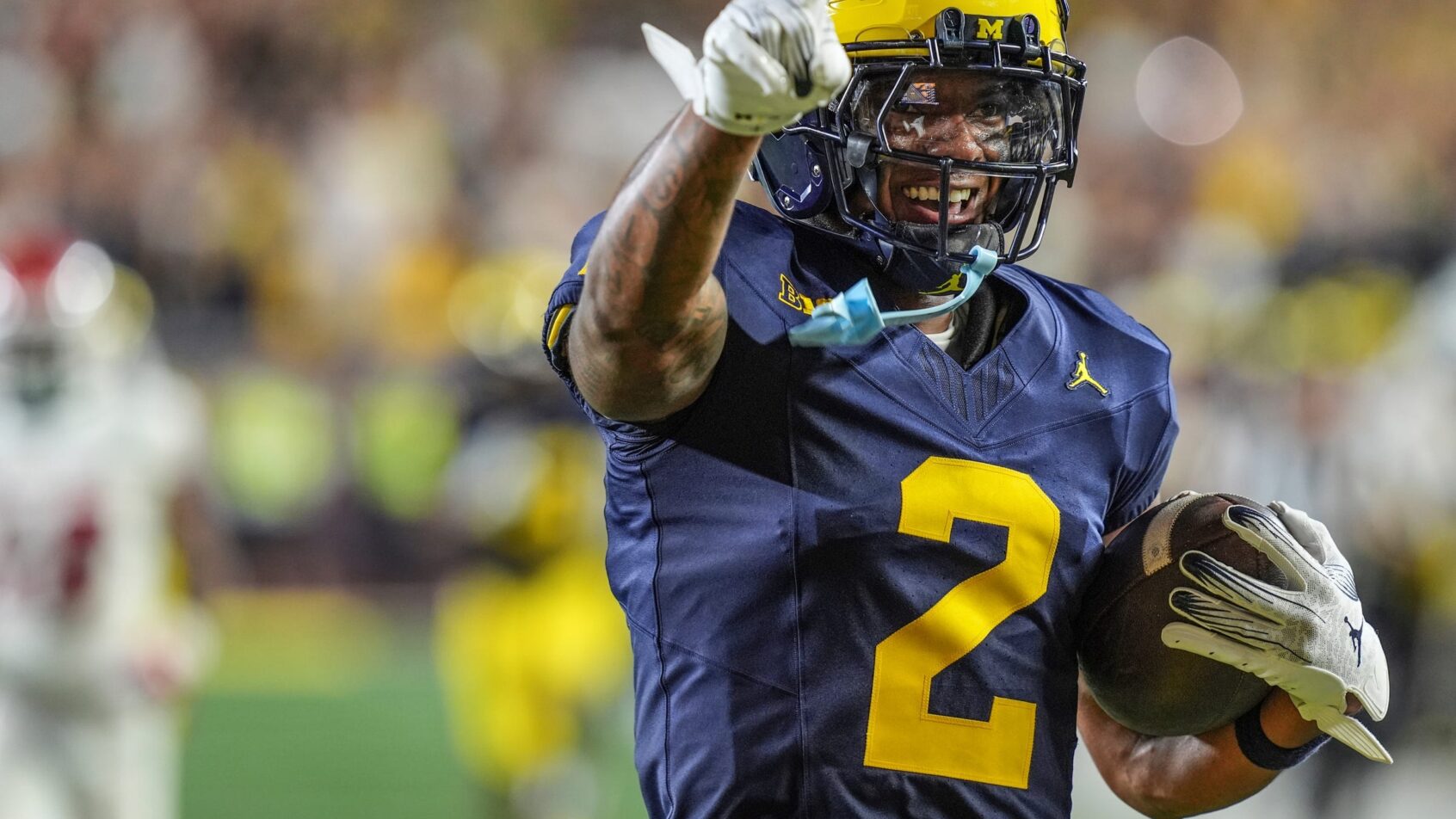 Will Johnson celebrates an interception for the Wolverines.