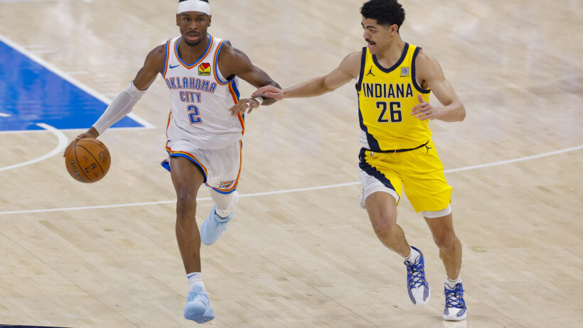 Oklahoma City Thunder guard Shai Gilgeous-Alexander brings the ball up the court as Indiana Pacers guard Ben Sheppard tries to catch-up