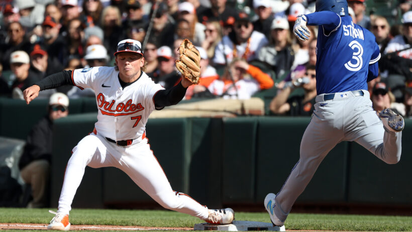 Toronto Blue Jays outfielder Myles Straw running to first base while Baltimore Orioles second baseman Jackson Holliday covers first on a sac bunt