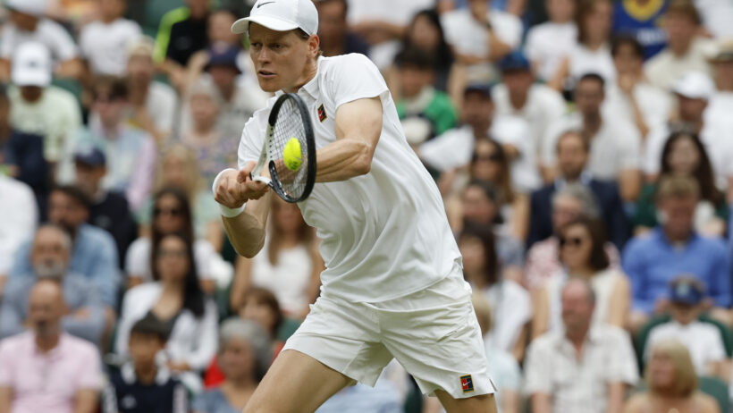 Jannik Sinner hitting a backhand at Wimbledon 2025