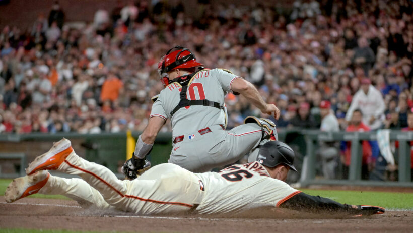 San Francisco Giants third baseman Matt Chapman slides into home ahead of the tag by Philadelphia Phillies catcher JT Realmuto
