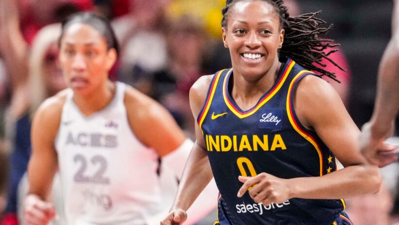 Indiana Fever guard Kelsey Mitchell smiles while running up the court against the Las Vegas Aces