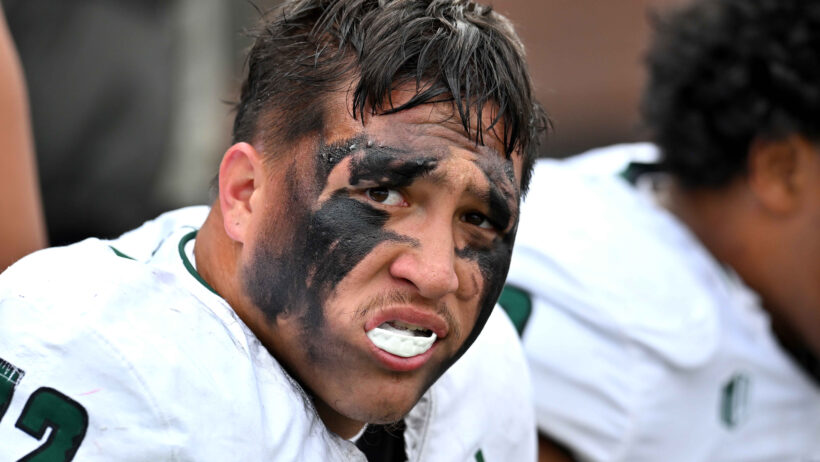 Micah Alejado helmet off sitting on sideline