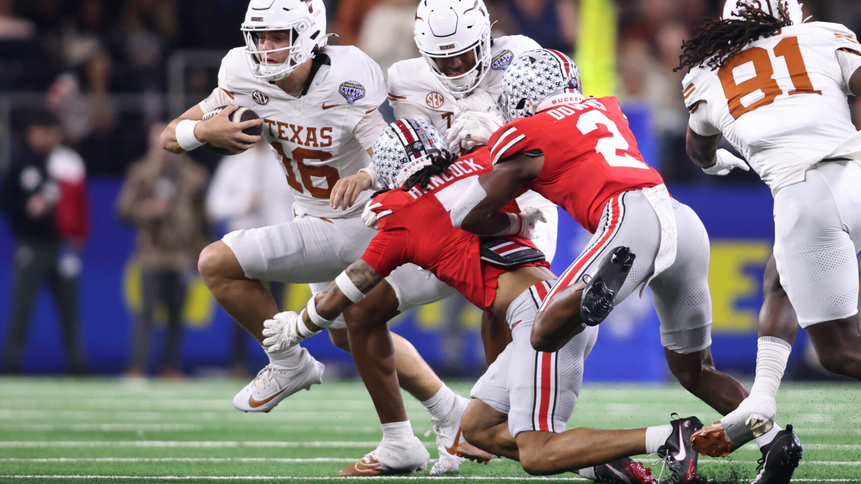 Texas Longhorns quarterback Arch Manning running with the ball as Ohio State defenders try to tackle him
