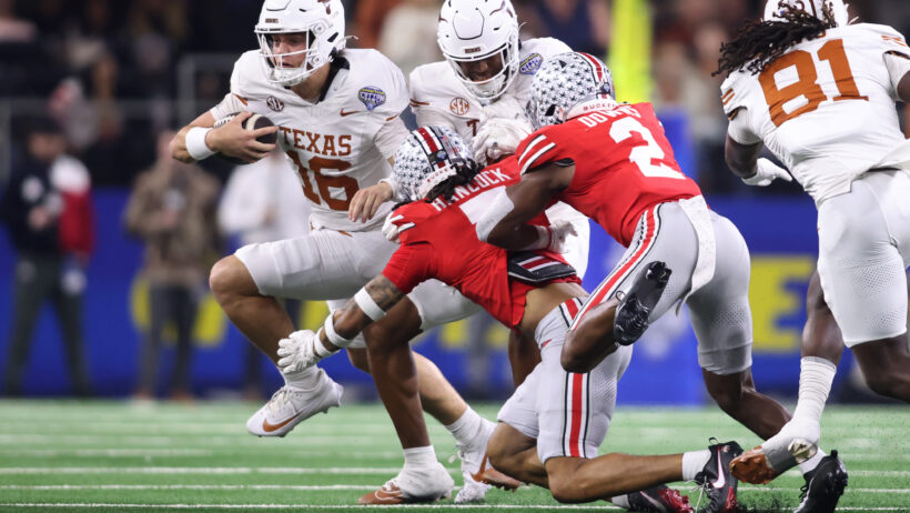 Texas Longhorns quarterback Arch Manning running with the ball as Ohio State defenders try to tackle him