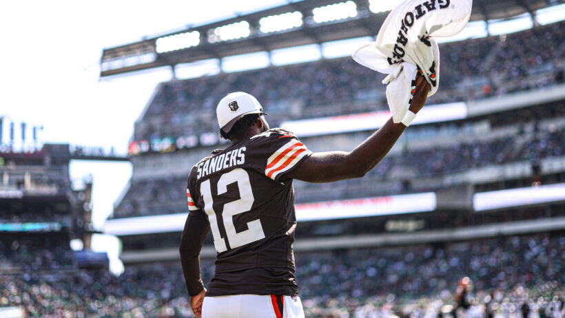 Cleveland Browns quarterback Shedeur Sanders waving a towel towards the crowd