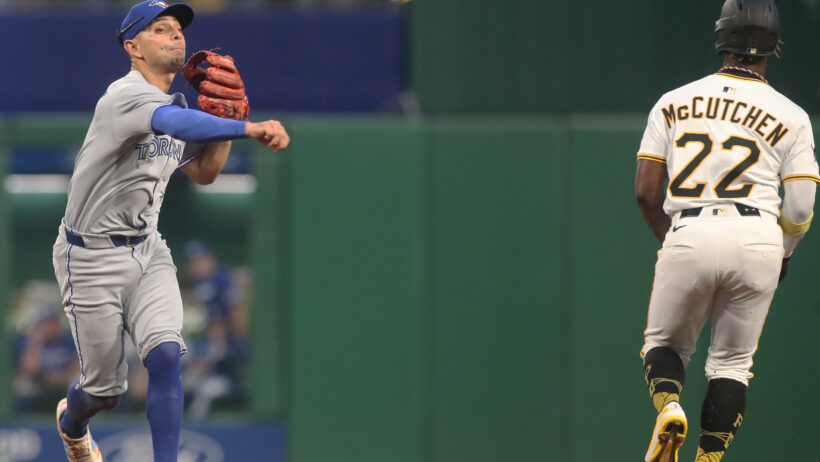 Toronto Blue Jays second baseman Andres Gimenez throwing to first to complete a double play