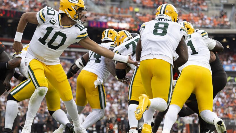 BET99 promo code for NFL Week 4. Jordan Love handing off to Josh Jacobs.