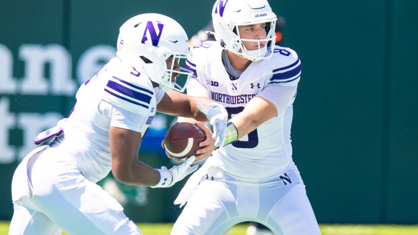 Northwestern Wildcats quarterback Preston Stone hands the ball off to running back Caleb Komolafe