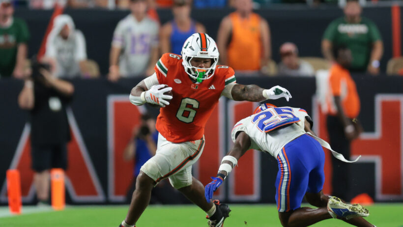 Miami Hurricanes running back CharMar Brown stiff arms a Florida Gators defender