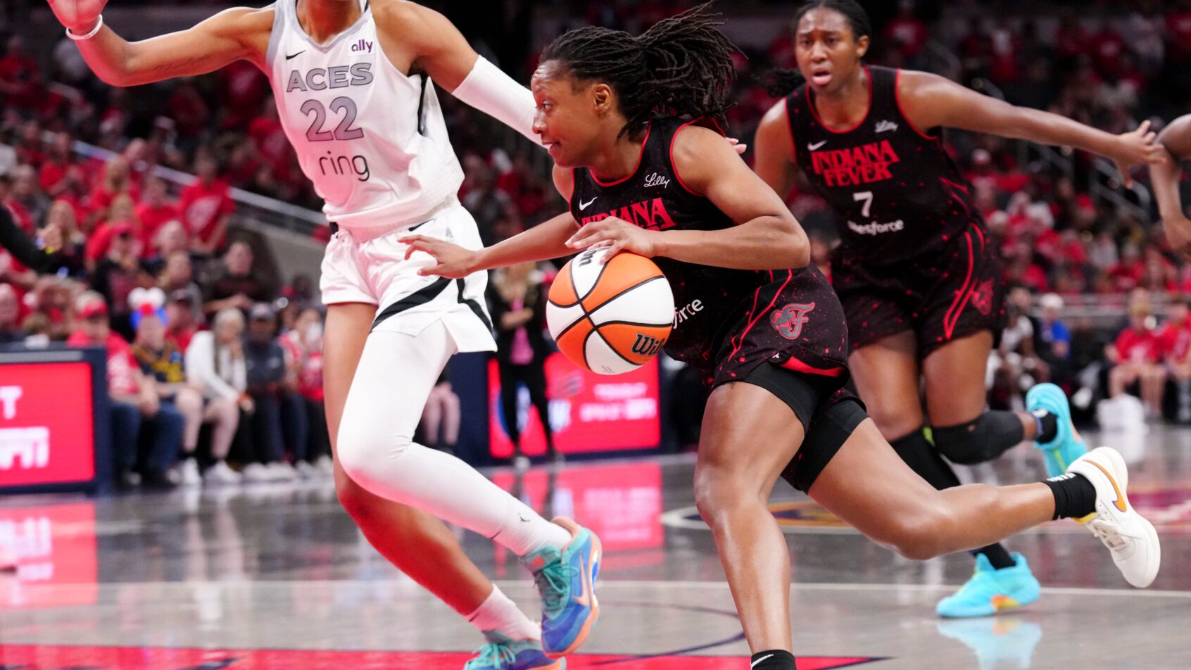 Indiana Fever guard Kelsey Mitchell drives to the basket as Las Vegas Aces center A'ja Wilson defends