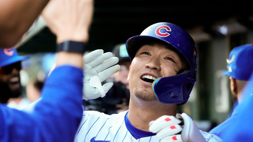 Chicago Cubs outfielder Seiya Suzuki high-fives teammates in the dugout after hitting a home run