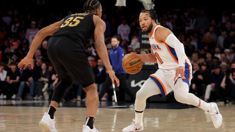 New York Knicks guard Jalen Brunson dribbling while Cleveland Cavaliers forward Isaac Okoro defends