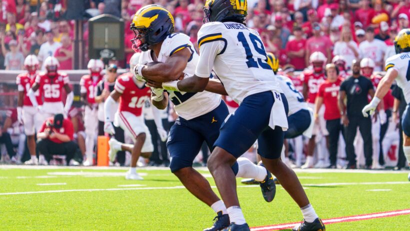 Michigan Wolverines quarterback Bryce Underwood hands the ball off to running back Justice Haynes
