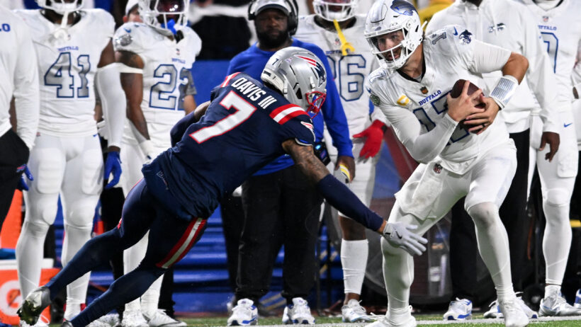 Josh Allen tries to slip past a Patriots defender.