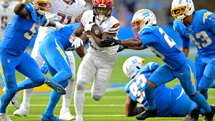 Jacory Croskey-Merritt running between Chargers defenders