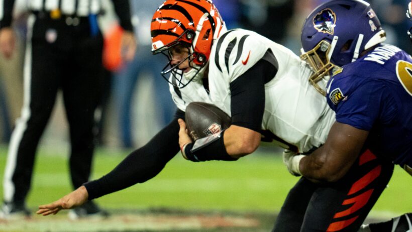 Baltimore Ravens defensive tackle Nnamdi Madubuike tackles Cincinnati Bengals quarterback Joe Burrow