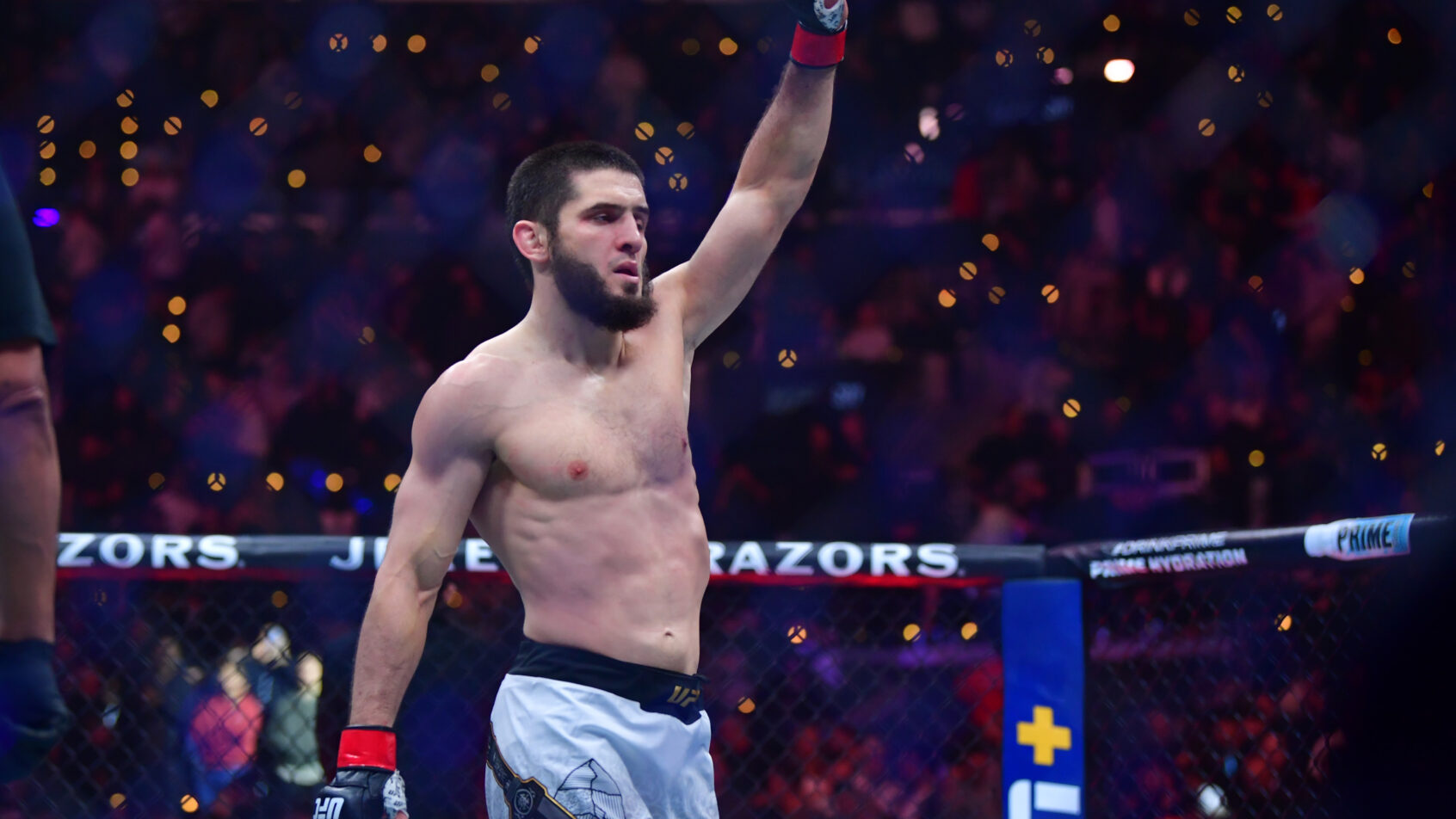 Islam Makhachev raises his hand in victory after defeating Renato Moicano.