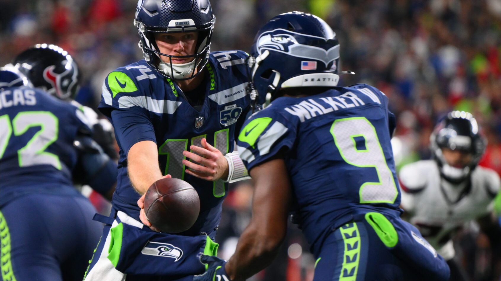 Seattle Seahawks quarterback Sam Darnold handing the ball off to running back Kenneth Walker III