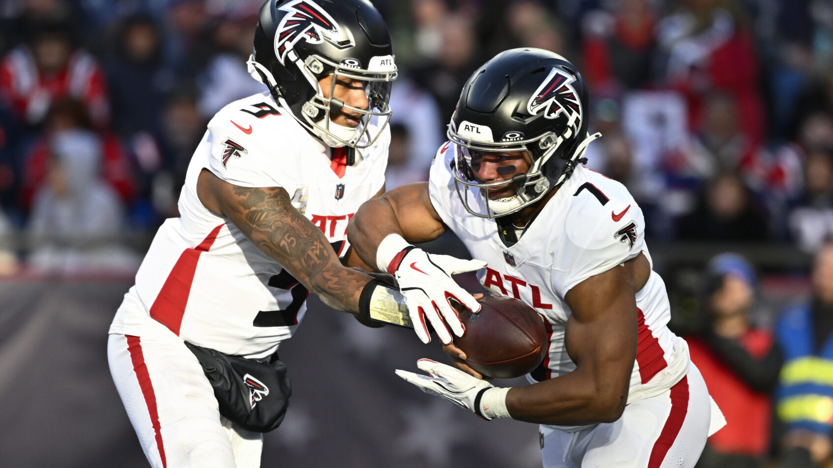 Atlanta Falcons quarterback Michael Penix Jr hands the ball off to running back Bijan Robinson