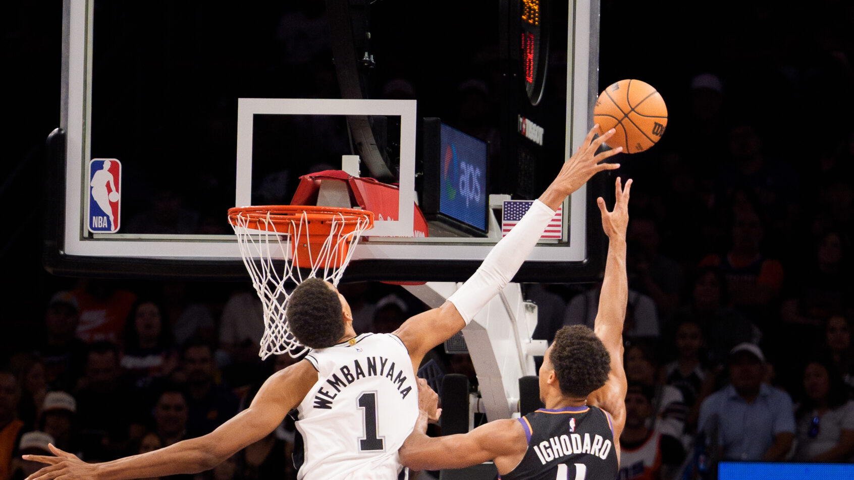 Victor Wembanyama extends to block a Oso Ighodaro shot in a Spurs vs Suns game.
